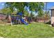 Spacious backyard featuring a wooden playset, lush lawn, and a wood fence perfect for outdoor activities at 2311 W 46Th Ave, Denver, CO 80211