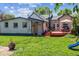 Backyard view of home featuring a red wood deck with outdoor seating, a lush green lawn, and mature trees at 2311 W 46Th Ave, Denver, CO 80211