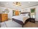 Bright bedroom featuring a ceiling fan, natural light, light-colored walls, wood trim, and a dark-stained wood bed frame at 2311 W 46Th Ave, Denver, CO 80211