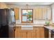 Well-lit kitchen with wood cabinets, farmhouse sink, and modern appliances at 2311 W 46Th Ave, Denver, CO 80211