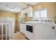 Laundry room with a tile floor, white cabinets, a white washer and dryer, and a window at 2311 W 46Th Ave, Denver, CO 80211