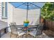 Cozy patio area with a round table, four chairs, blue umbrella, and a potted plant, ideal for outdoor relaxation at 2311 W 46Th Ave, Denver, CO 80211
