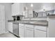 A modern kitchen featuring stainless steel appliances, granite countertops, and white cabinetry at 17442 Nature Walk Trl # 105, Parker, CO 80134