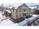 Rear exterior view of a well-maintained home with stone accents and snow-covered yard, offering privacy at 5906 S Youngfield Way, Littleton, CO 80127