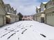 Townhomes with attached garages and snow-covered driveways during winter at 5906 S Youngfield Way, Littleton, CO 80127