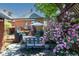 Spacious backyard featuring stone patio, seating, and a garden full of pink roses at 669 S Washington St, Denver, CO 80209
