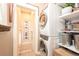 Convenient laundry room with stacked washer and dryer, shelving, and adjacent storage space at 669 S Washington St, Denver, CO 80209
