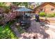 Backyard stone patio with outdoor dining set and blooming pink roses at 669 S Washington St, Denver, CO 80209