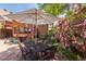 Backyard patio with dining set and shade umbrella surrounded by roses at 669 S Washington St, Denver, CO 80209
