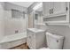 Cozy bathroom with white tile, shower-tub combo, and vanity with storage at 6895 W Oregon Dr, Lakewood, CO 80232