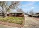 Inviting single-story home featuring a well maintained front yard, brick accents, long driveway and detached garage at 6895 W Oregon Dr, Lakewood, CO 80232