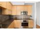 The modern kitchen features wooden cabinets, gray backsplash and stainless steel appliances at 340 S Lafayette St # 201, Denver, CO 80209