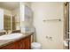 Bathroom featuring a vanity with a sink, storage cabinet, toilet and a shower with a glass door at 19029 E 58Th Ave, Denver, CO 80249