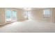 Bright living room with neutral carpet, large windows, and a sliding glass door to the outdoor area at 19029 E 58Th Ave, Denver, CO 80249