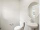 Powder room with pedestal sink, oval mirror, and low-flow toilet at 379 Remuda Rd, Berthoud, CO 80513