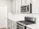 Close-up of the kitchen showcasing stainless steel appliances, gray cabinets, and white countertops at 379 Remuda Rd, Berthoud, CO 80513