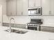 Close-up of a kitchen featuring stainless steel appliances, light gray cabinets, subway tile backsplash, and quartz countertops at 379 Remuda Rd, Berthoud, CO 80513
