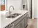 Close up of the kitchen featuring a stainless steel sink with quartz countertops and gray cabinets at 379 Remuda Rd, Berthoud, CO 80513