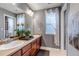 Bathroom featuring double sinks with dark wood cabinetry and neutral gray walls, along with a separate toilet area at 6345 S Ider Way, Aurora, CO 80016