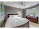 Comfortable bedroom with a ceiling fan, a large window, and dark wood furniture at 6345 S Ider Way, Aurora, CO 80016