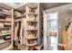 Large closet with wood floors, built in shelving, clothing racks and views into the bathroom at 6345 S Ider Way, Aurora, CO 80016