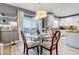 Bright dining room features modern chandelier, glass table, and sliding doors to the deck at 6345 S Ider Way, Aurora, CO 80016