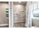 Walk-in shower features pebble tile flooring, grab bars, a shower seat and mosaic tile accent wall at 6345 S Ider Way, Aurora, CO 80016