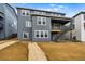 Rear view of a modern three-story home with a walkout basement and a wooden staircase to the backyard at 9322 Quaker St, Arvada, CO 80007
