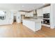 Modern open concept kitchen featuring an island, stainless appliances, and pantry access at 9322 Quaker St, Arvada, CO 80007