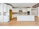 Modern kitchen with white cabinets, a large island, stainless appliances, and wood flooring at 9322 Quaker St, Arvada, CO 80007