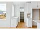 Modern kitchen featuring sleek white cabinets, pantry, and natural light from large windows at 9322 Quaker St, Arvada, CO 80007