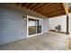 View of patio with sliding glass door, wood beams, and grey wood paneling at 9322 Quaker St, Arvada, CO 80007