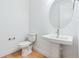 This powder room features a pedestal sink, modern fixtures, and a wood grain floor at 9322 Quaker St, Arvada, CO 80007