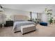 Well-lit main bedroom featuring a tufted headboard, ceiling fan, and cozy sitting area at 12366 Nate Cir, Parker, CO 80134