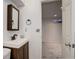 A half bathroom with a single sink vanity next to basement utility access at 7552 Garland St, Arvada, CO 80005