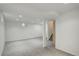 A finished basement with gray carpet, neutral walls, and access to the stairwell at 7552 Garland St, Arvada, CO 80005