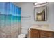 Bathroom with blue ocean themed shower curtain at 7552 Garland St, Arvada, CO 80005