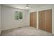 Bright bedroom featuring neutral carpet, a ceiling fan, and double-door closet for ample storage at 7552 Garland St, Arvada, CO 80005