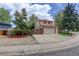 View of a two-story house with an attached two-car garage, driveway, lawn, and wooden fence at 7552 Garland St, Arvada, CO 80005
