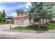 Two-story home with a front lawn, mature trees, a driveway, and an attached two-car garage at 7552 Garland St, Arvada, CO 80005
