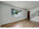 Bright living room with hardwood floors, a large window, front door, and staircase at 7552 Garland St, Arvada, CO 80005