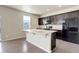 Kitchen featuring dark cabinets, light countertops, and a center island with a sink at 467 S 36Th Ave, Brighton, CO 80601