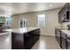 Kitchen featuring dark cabinets, light countertops, and a center island with a sink at 467 S 36Th Ave, Brighton, CO 80601