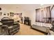 Spacious finished basement with a comfy recliner, fireplace, treadmill and bronze-colored window drapes at 11746 Elizabeth Cir, Thornton, CO 80233