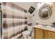 Bathroom featuring a striped shower curtain, patterned mirror, and plenty of storage at 11746 Elizabeth Cir, Thornton, CO 80233