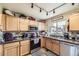 Efficient kitchen showcasing wood cabinets, countertops, stainless steel appliances and modern fixtures at 11746 Elizabeth Cir, Thornton, CO 80233