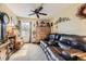 Cozy living room featuring a large brown couch, ceiling fan, and natural light at 11746 Elizabeth Cir, Thornton, CO 80233