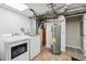 Unfinished basement space with laundry hookups, mechanicals, and a utility sink at 6393 S Johnson St, Littleton, CO 80123