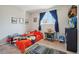 Bedroom with a window, toys, a desk and a bed covered in an orange comforter at 6393 S Johnson St, Littleton, CO 80123