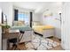 Bright bedroom features two beds, desk, neutral decor, and large window at 5735 N Genoa Way # 11-205, Aurora, CO 80019